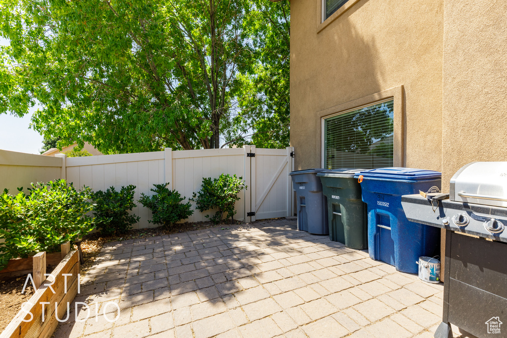 View of patio with a gate and area for grilling