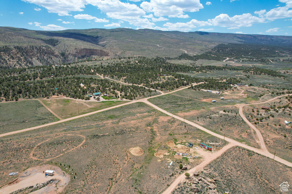 Aerial view of property's location with a mountain backdrop, property parcel outlined, and rural landscape