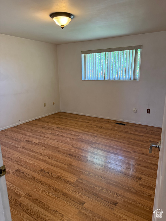 Empty room with healthy amount of natural light and wood finished floors