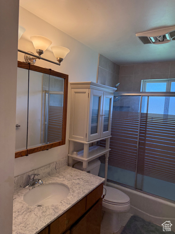 Full bath featuring vanity and combined bath / shower with glass door