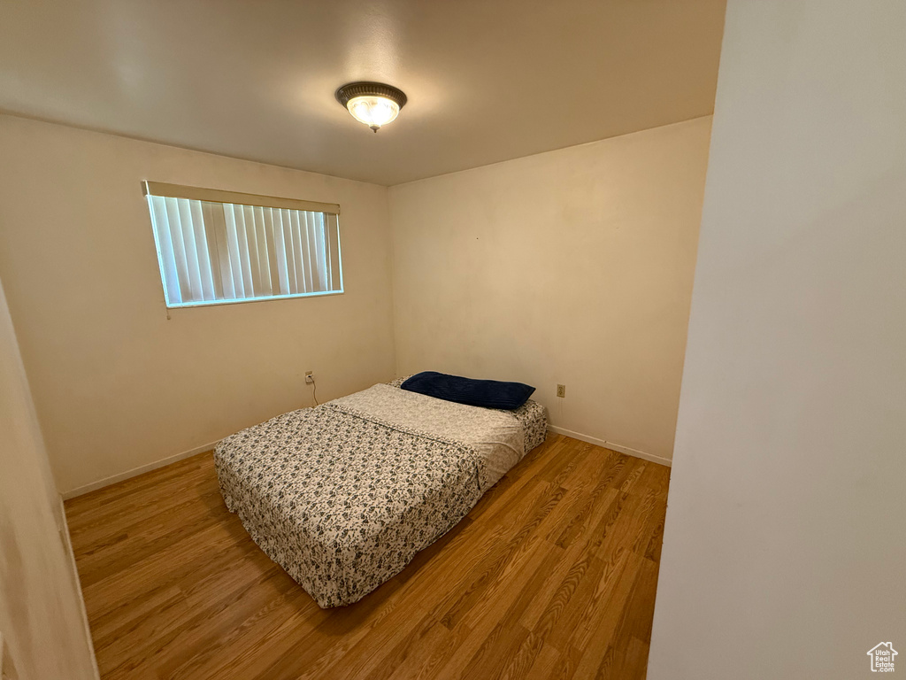 Bedroom with wood finished floors and baseboards