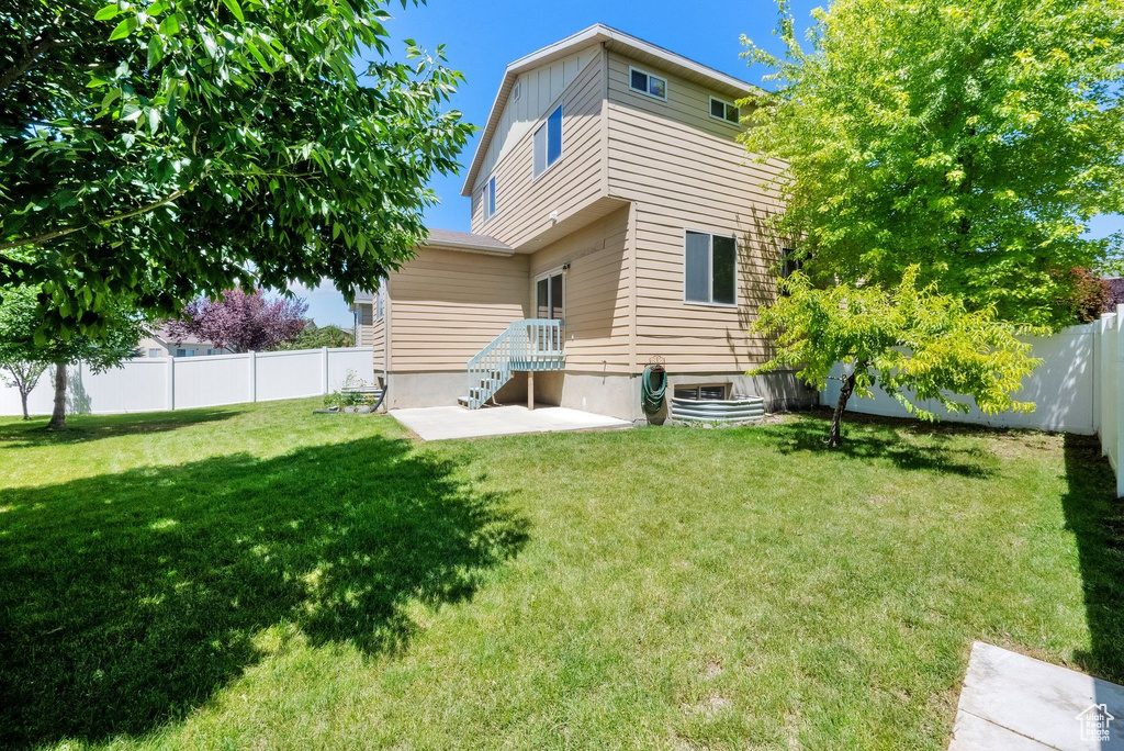 Back of house featuring a fenced backyard and a patio