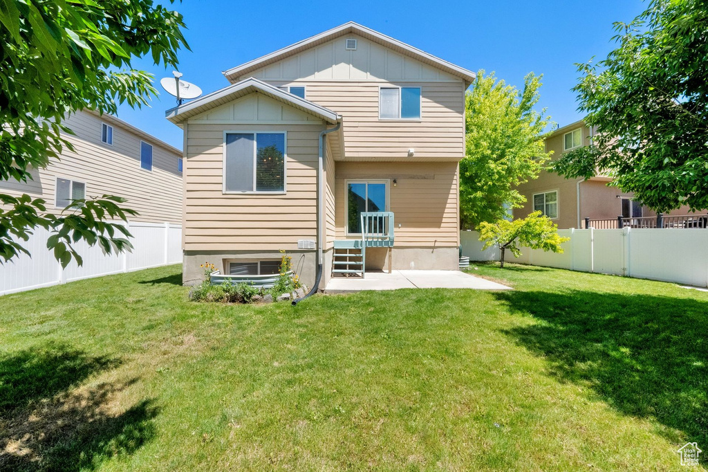 Back of house featuring board and batten siding, a fenced backyard, and a patio area