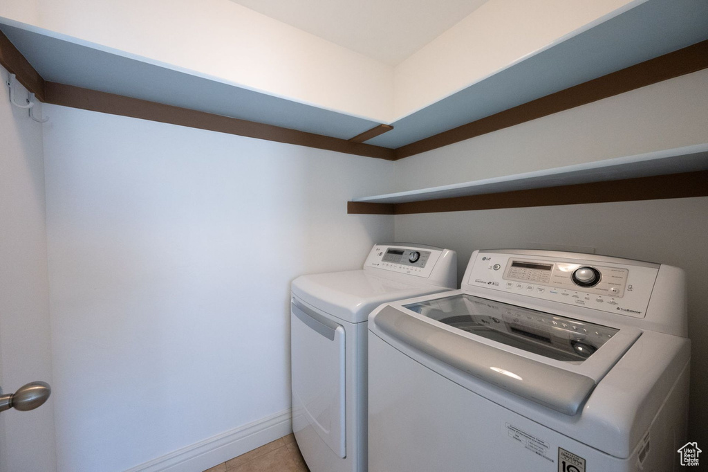 Washroom featuring independent washer and dryer and light tile patterned floors