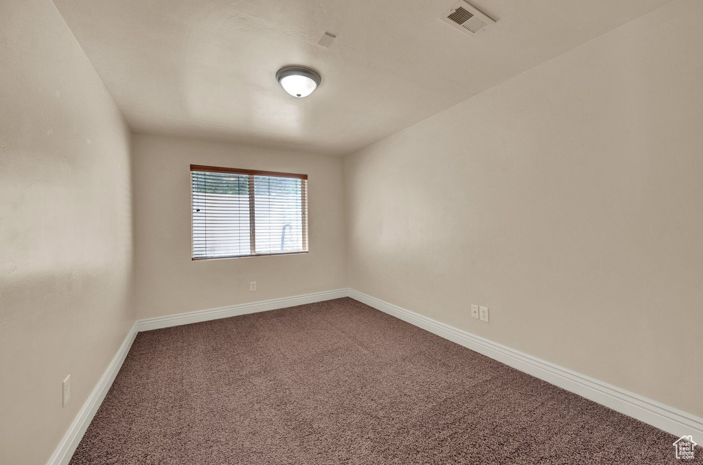 Carpeted spare room with baseboards