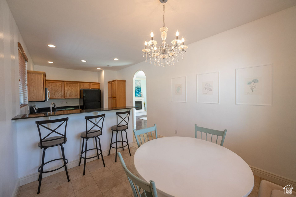 Dining area with arched walkways, recessed lighting, a chandelier, and light tile patterned flooring