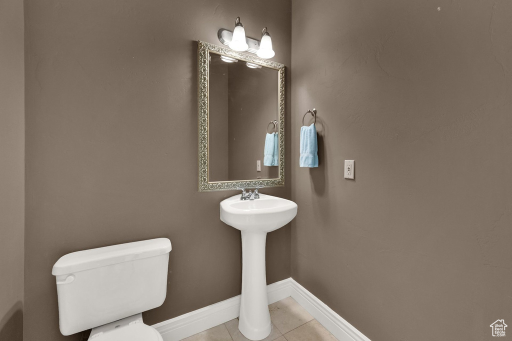 Half bath with toilet and tile patterned floors