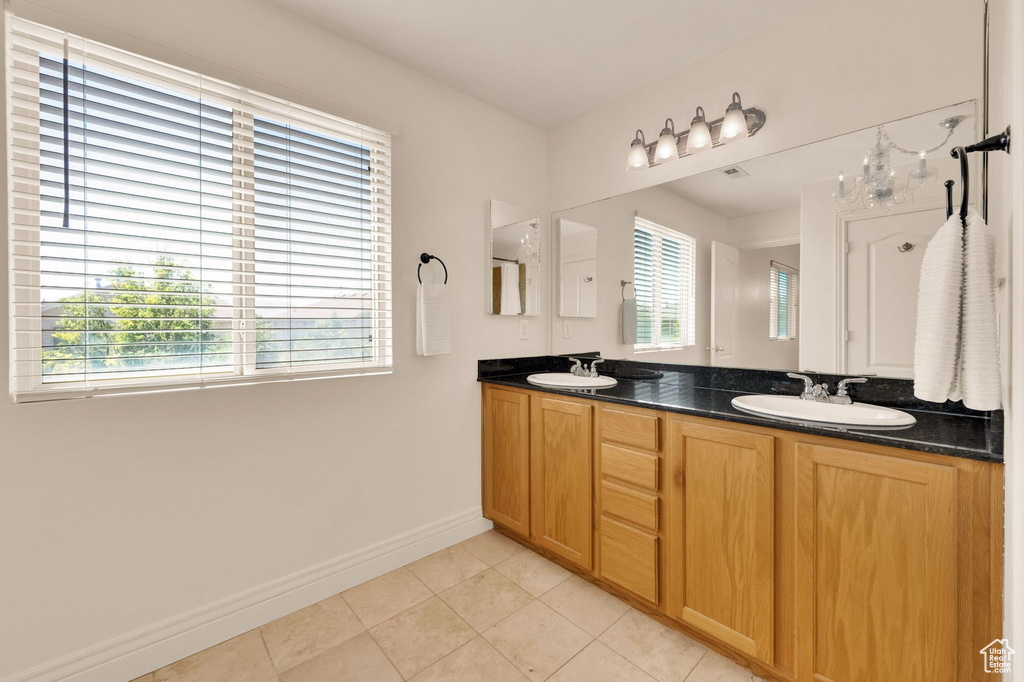 Bathroom with double vanity and tile patterned flooring