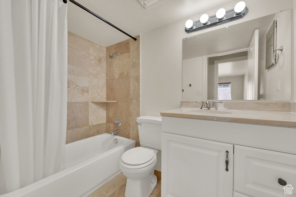 Bathroom featuring shower / bath combo with shower curtain and vanity