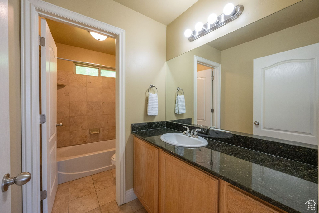 Full bathroom with vanity, tile patterned floors, and shower / washtub combination