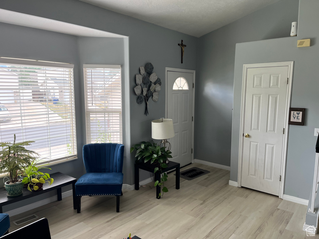 Foyer entrance with light wood-type flooring and baseboards