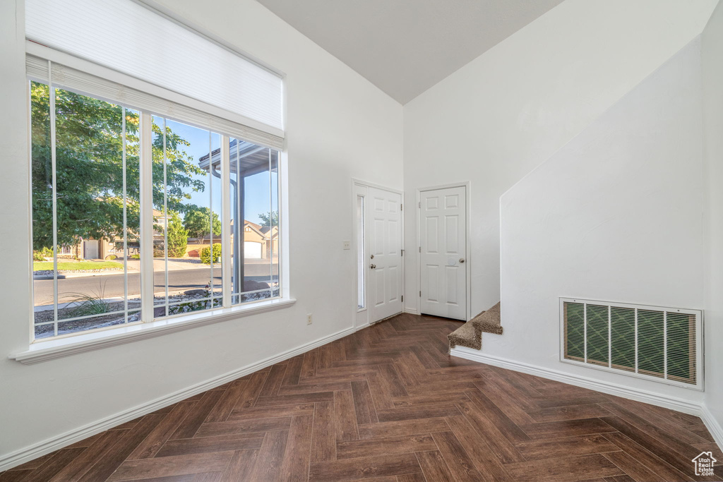 Unfurnished room featuring baseboards and a towering ceiling