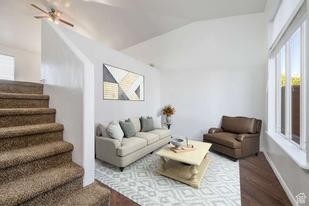 Living room with wood finished floors, lofted ceiling, stairs, and ceiling fan