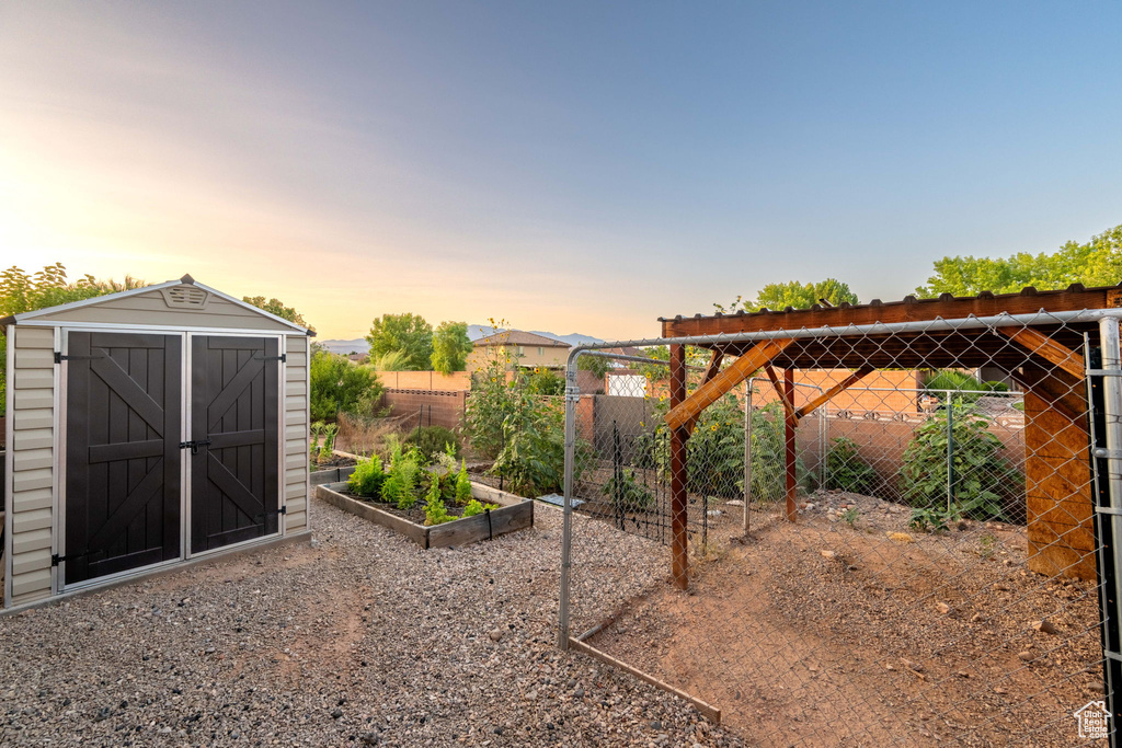 View of yard featuring a vegetable garden and a storage unit