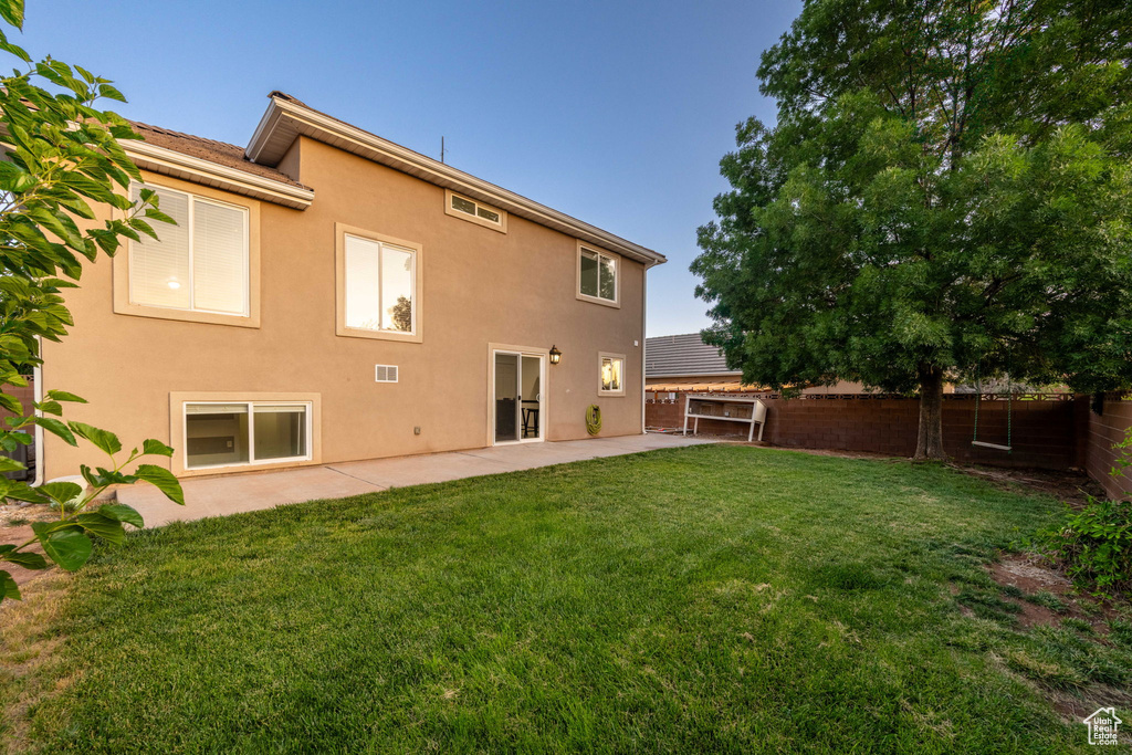 Rear view of house featuring a fenced backyard, a patio area, and stucco siding