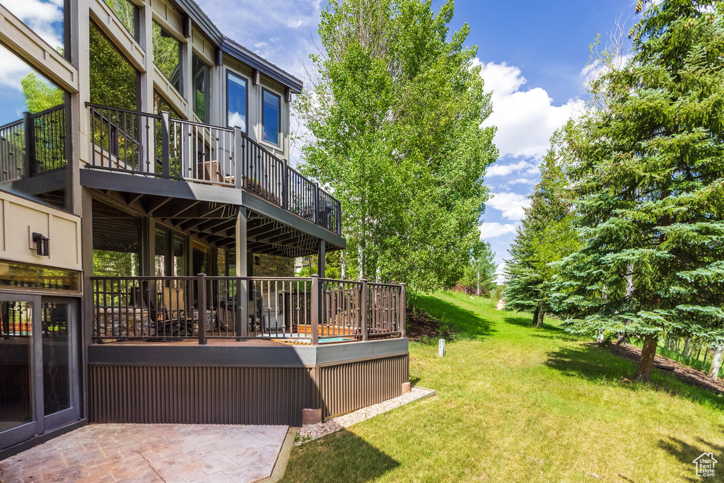 View of grassy yard featuring a wooden deck