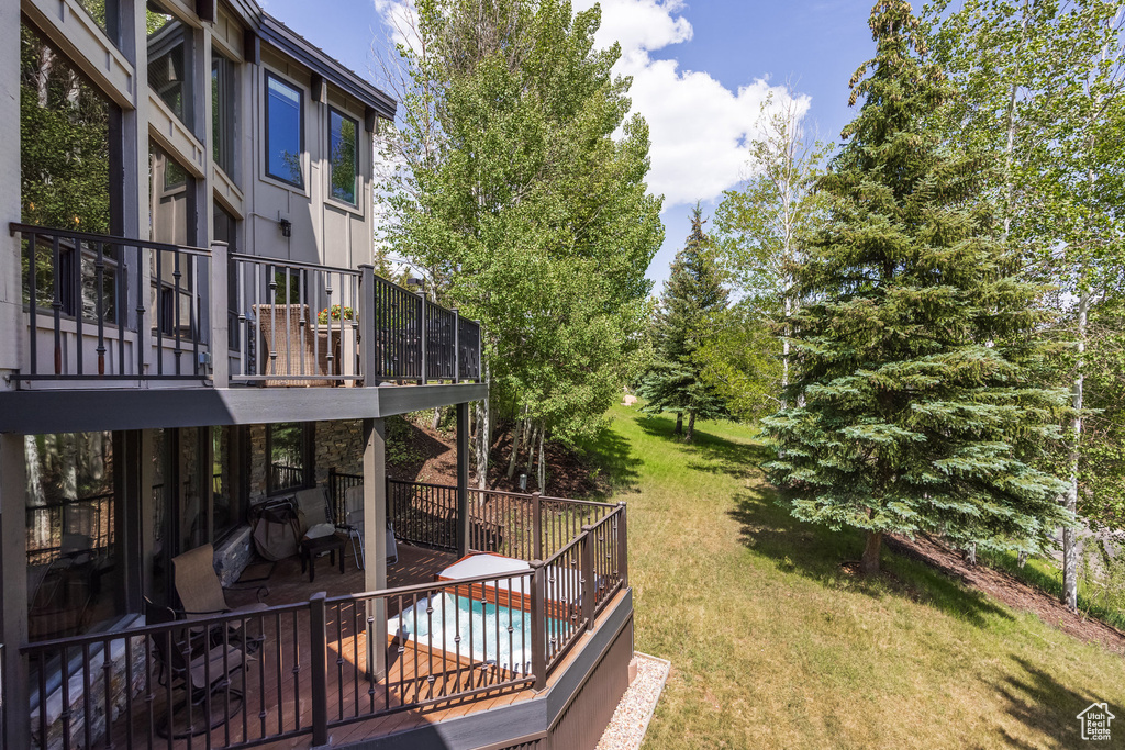View of grassy yard featuring a patio area and a deck
