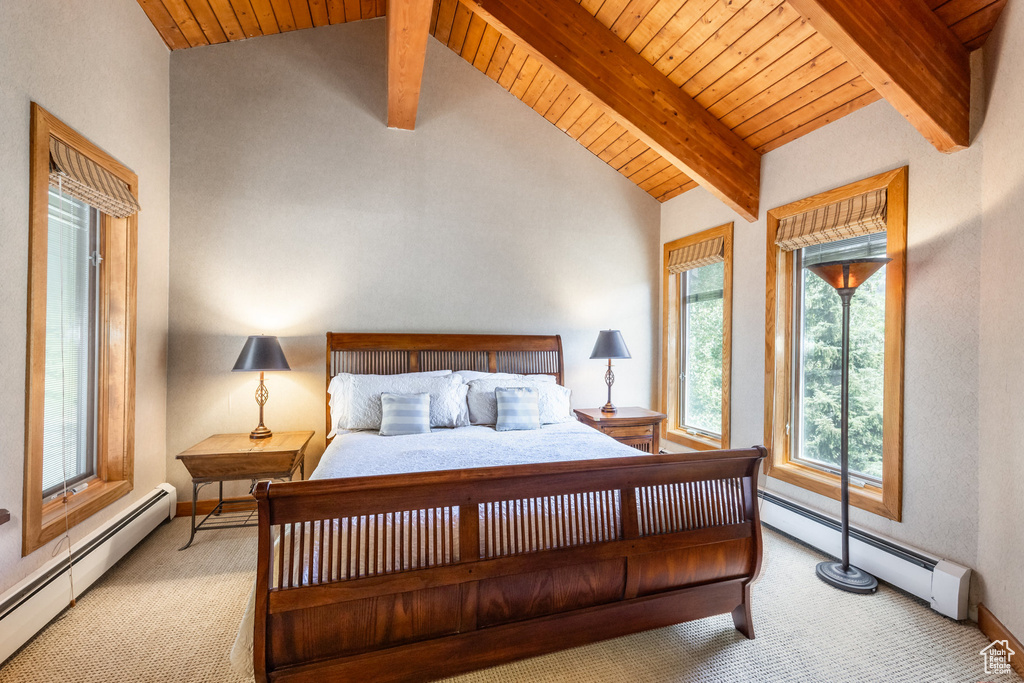 Carpeted bedroom featuring a baseboard radiator and wood ceiling