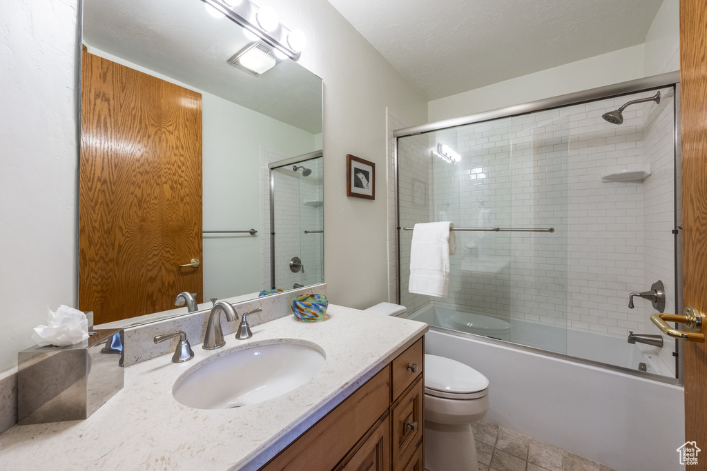 Full bath with vanity and combined bath / shower with glass door