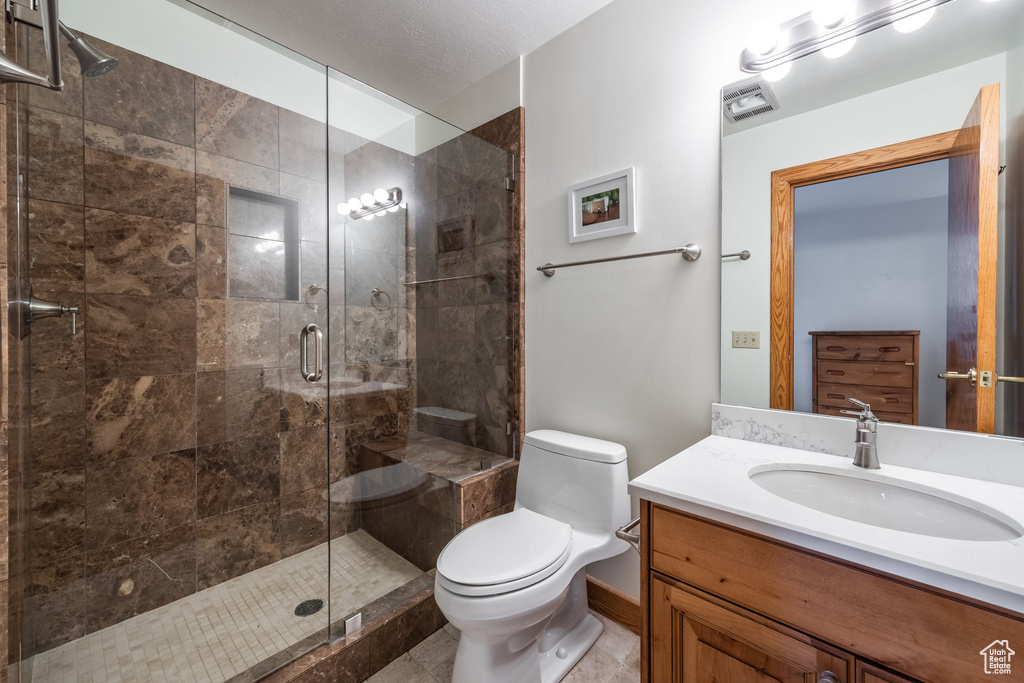 Full bathroom featuring vanity, a shower stall, and tile patterned floors