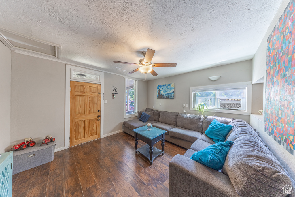 Living room featuring a textured ceiling, wood finished floors, ceiling fan, and cooling unit
