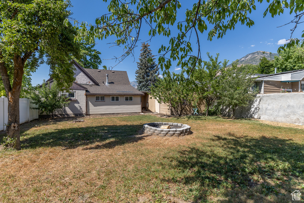 Fenced backyard with a fire pit and a mountain view