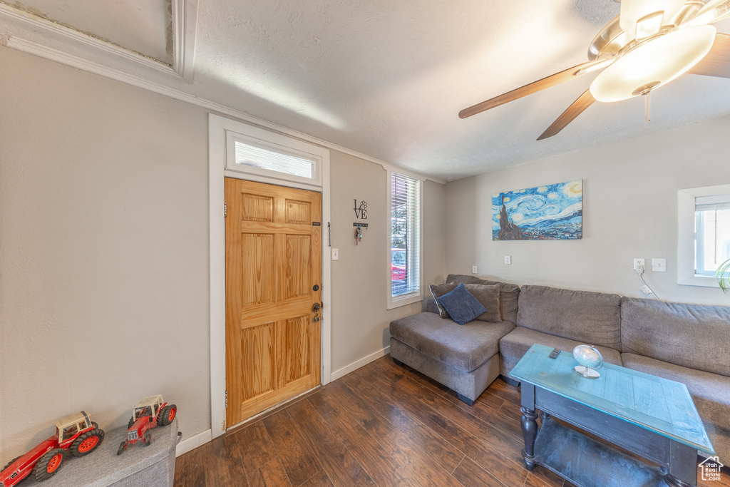 Living area featuring dark wood finished floors and a ceiling fan