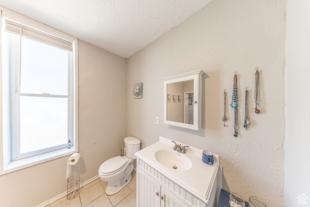Half bath with vanity and tile patterned floors