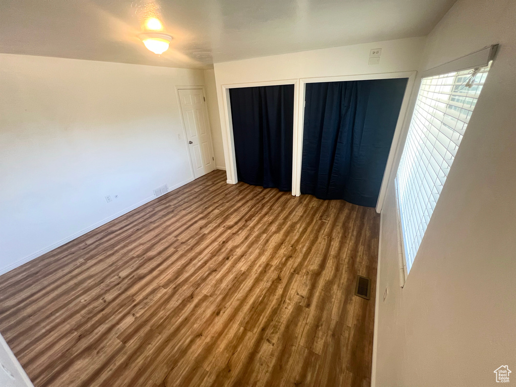Empty room with wood finished floors and plenty of natural light