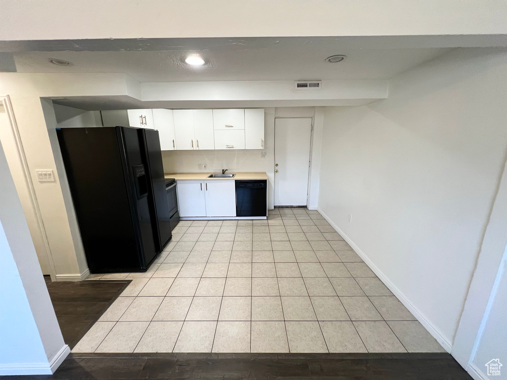 Kitchen with black appliances, light countertops, white cabinetry, light tile patterned floors, and recessed lighting