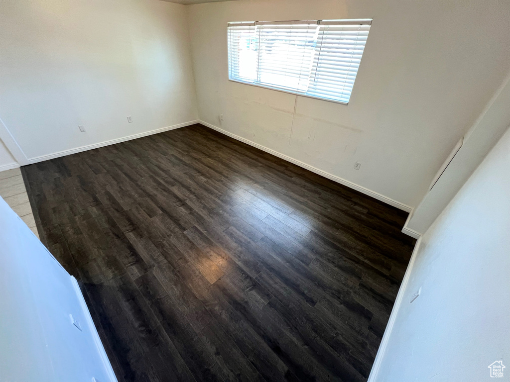Spare room with dark wood-style flooring