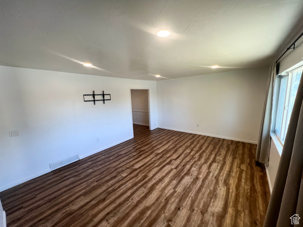 Unfurnished room featuring dark wood finished floors and recessed lighting