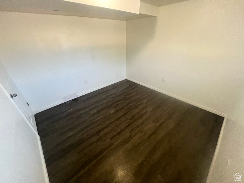 Spare room with dark wood-style floors