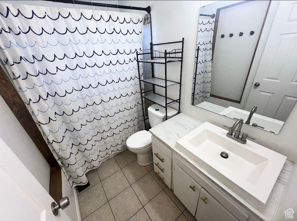 Bathroom with vanity, tile patterned flooring, and a shower with curtain