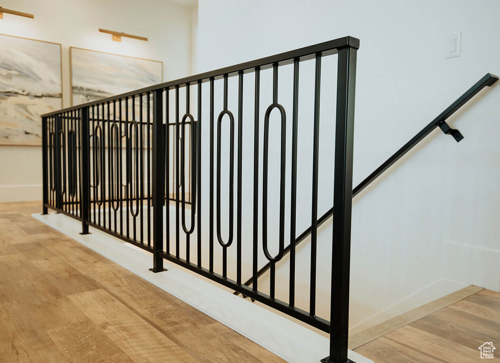 Stairway with wood finished floors and baseboards