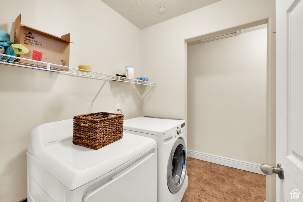 Laundry area with independent washer and dryer and baseboards