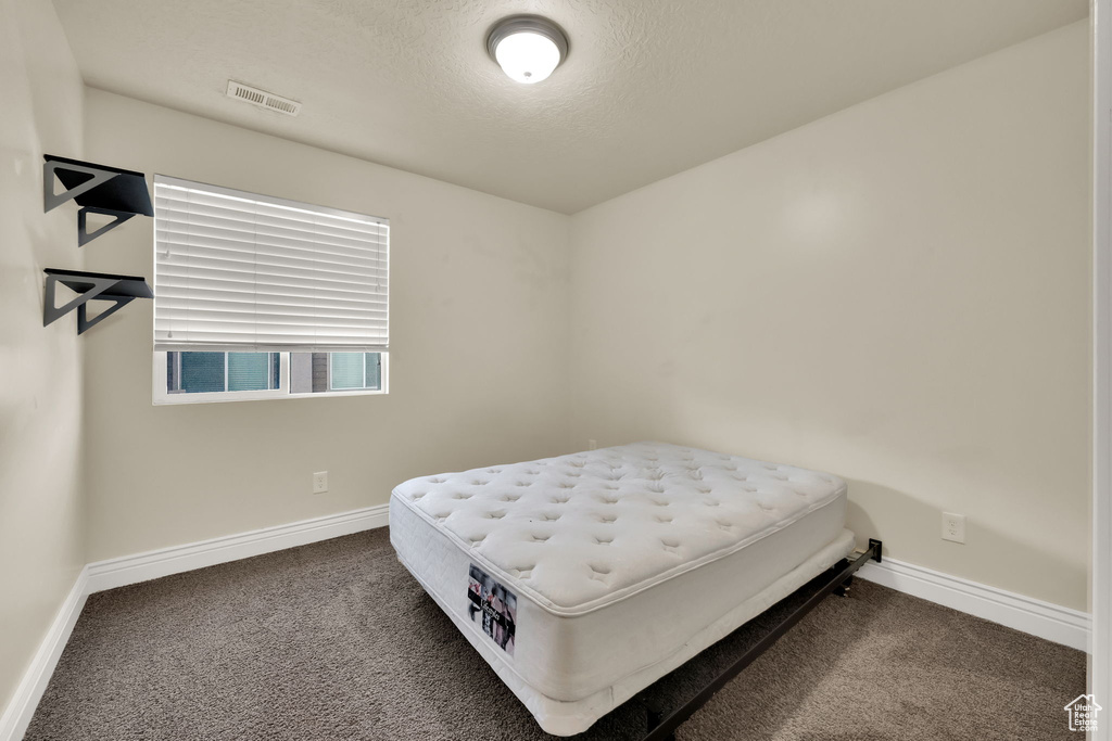 Bedroom featuring carpet floors and a textured ceiling