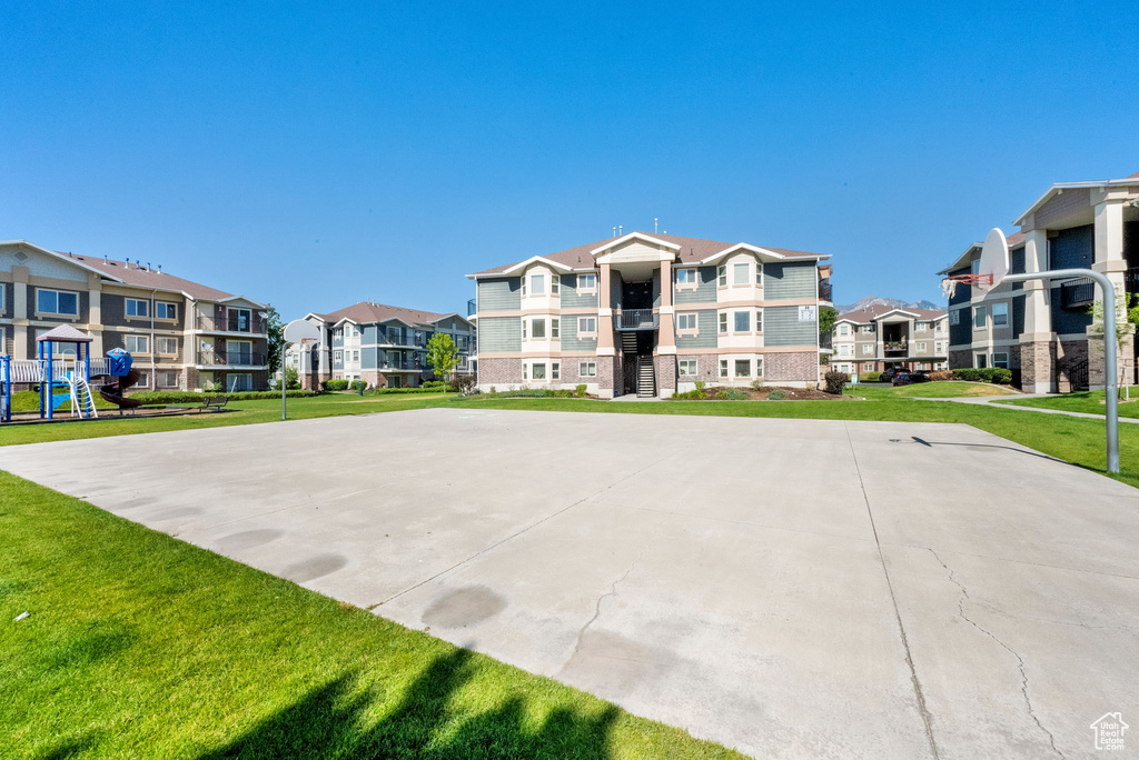 View of sport court featuring community basketball court, a residential view, and a yard