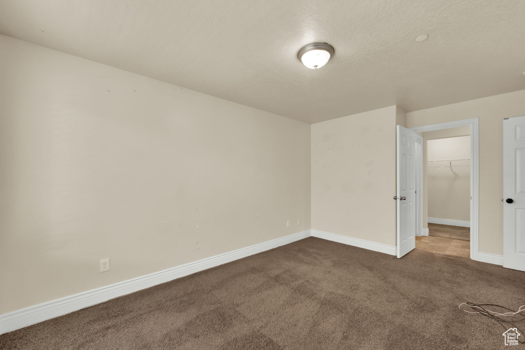 Spare room featuring carpet floors and a textured ceiling