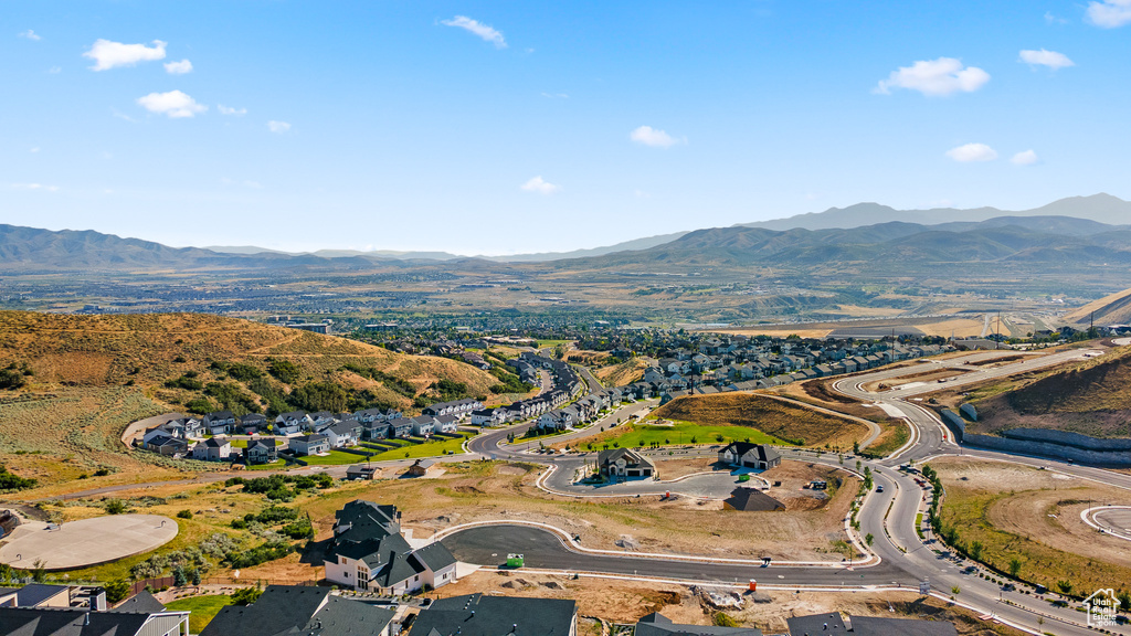 Aerial view of property and surrounding area with a mountain backdrop and nearby suburban area