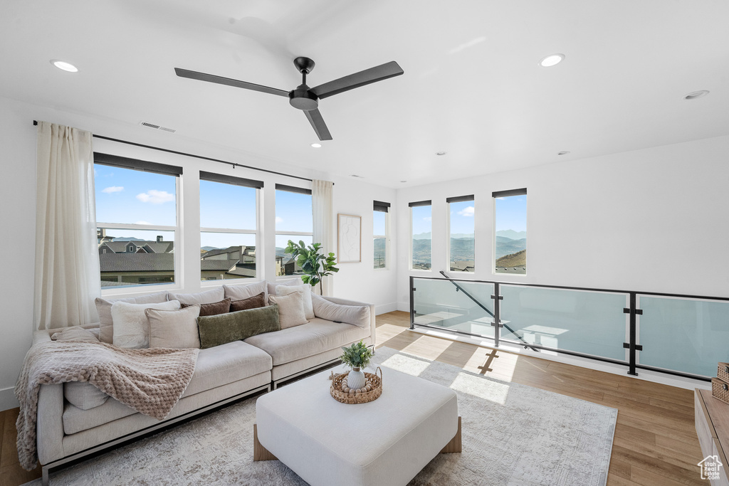 Living room featuring light wood-type flooring, a ceiling fan, and recessed lighting