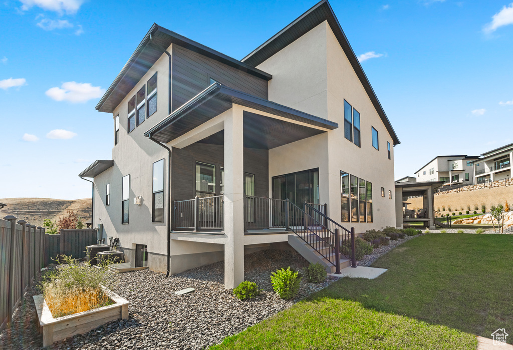 Back of property featuring covered porch and stucco siding