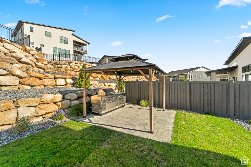 View of yard with a gazebo, a patio area, and an outdoor kitchen