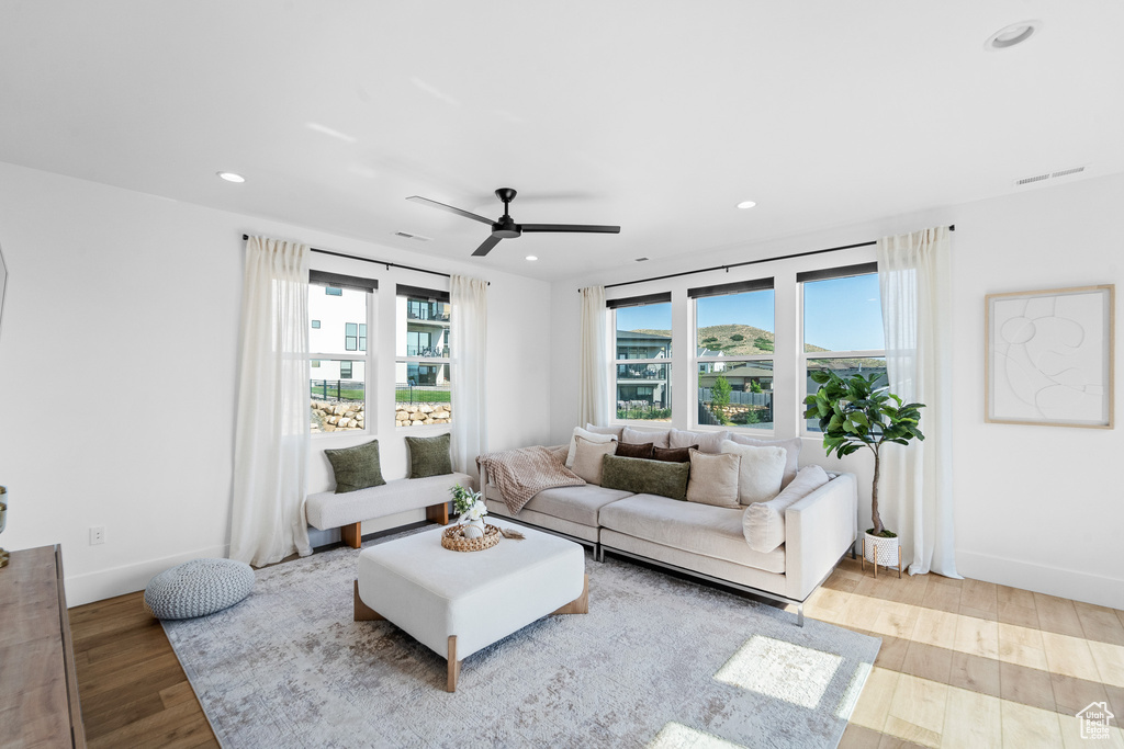 Living area with wood finished floors, a ceiling fan, and recessed lighting