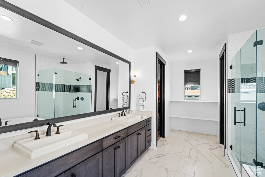 Bathroom featuring a shower stall, marble finish floors, recessed lighting, and double vanity