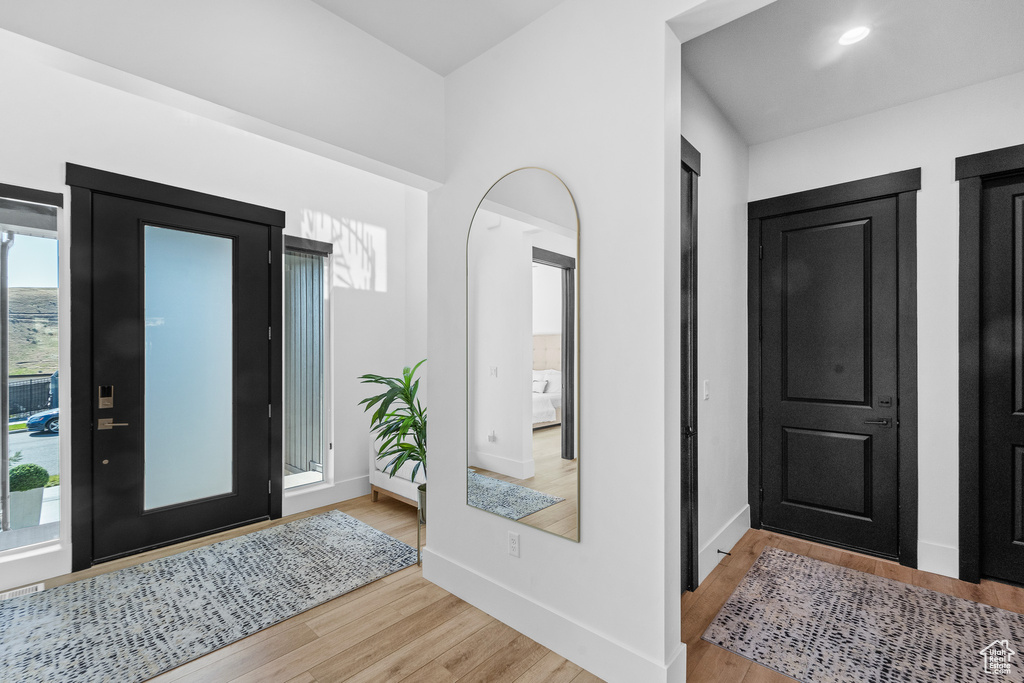 Foyer with wood finished floors and arched walkways