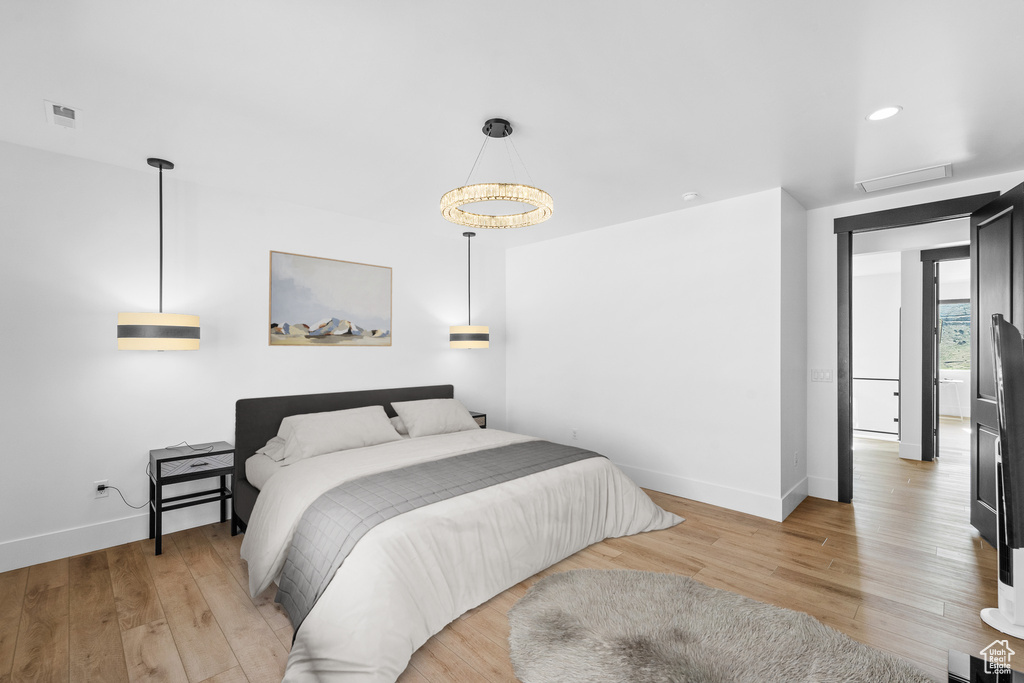 Bedroom with light wood-style flooring, attic access, and recessed lighting