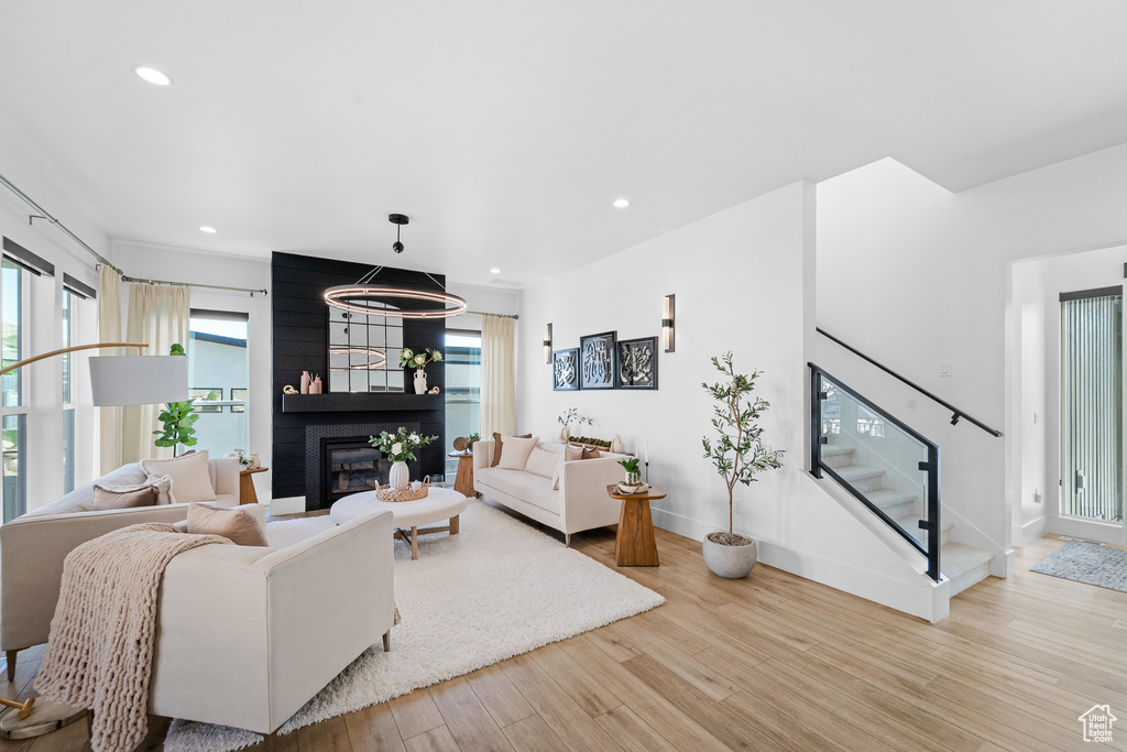 Living room featuring wood finished floors, a fireplace, recessed lighting, and stairway
