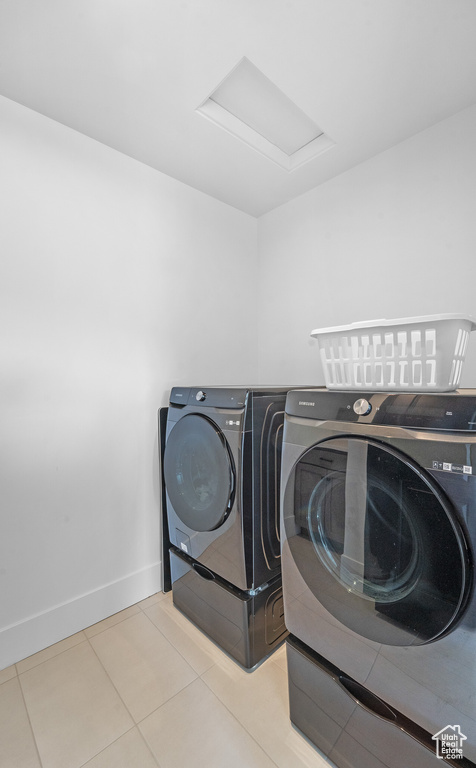 Laundry area featuring washing machine and clothes dryer, attic access, and tile patterned flooring