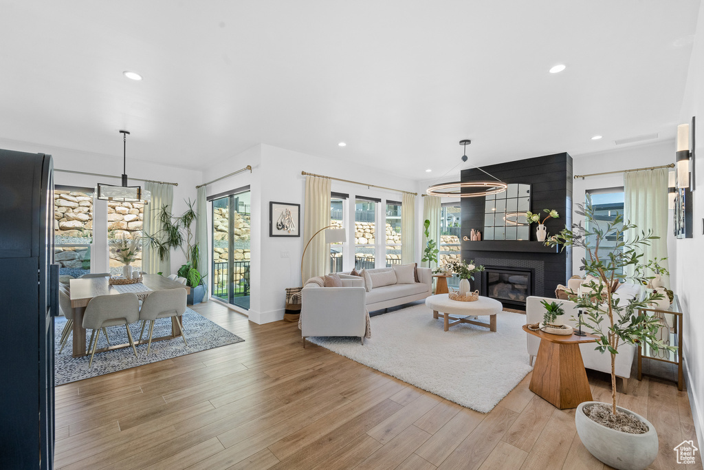 Living room featuring light wood-type flooring, recessed lighting, and a fireplace